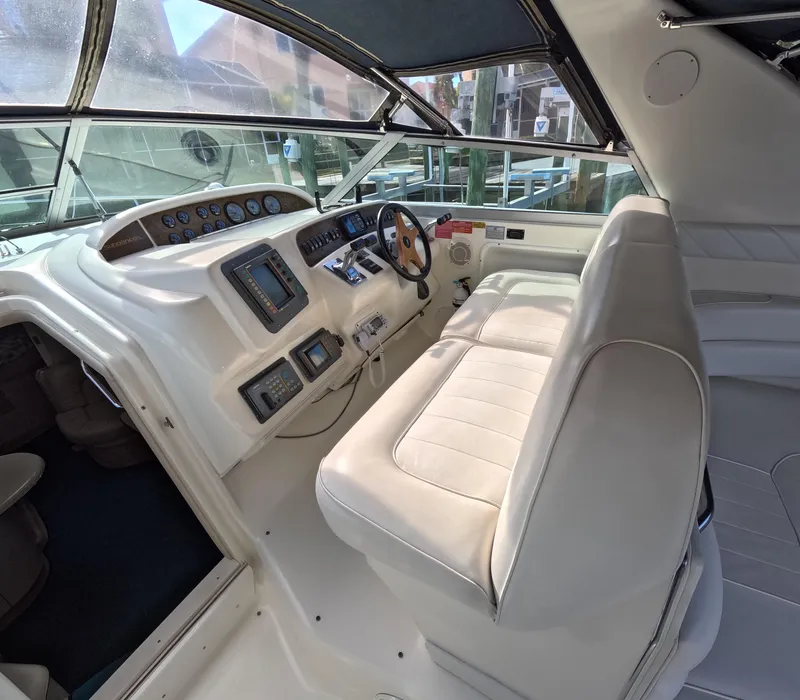 Slide: The Image of 1995 Sea Ray 370 Sundancer helm with white leather seating and navigation instruments. - 36