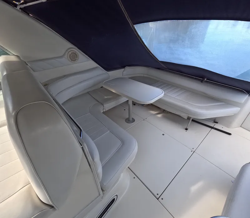 Slide: The Image of Interior seating area of 1995 Sea Ray 370 Sundancer with table and cushioned seats. - 38