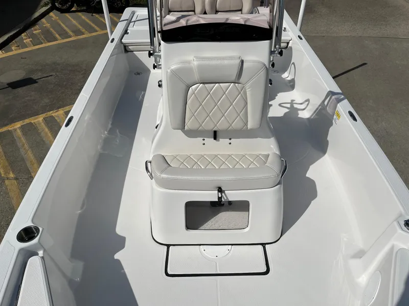 Slide: The Image of 2023 Blue Wave 2200 STL boat interior with white cushioned seating and storage compartment. - 11