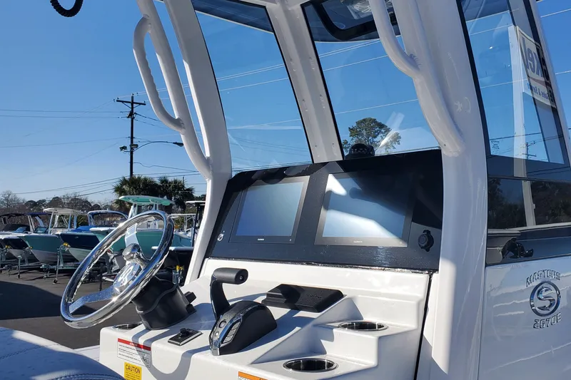 Slide: The Image of 2024 Sportsman Masters 267OE Bay boat console with dual screens and steering wheel. - 3