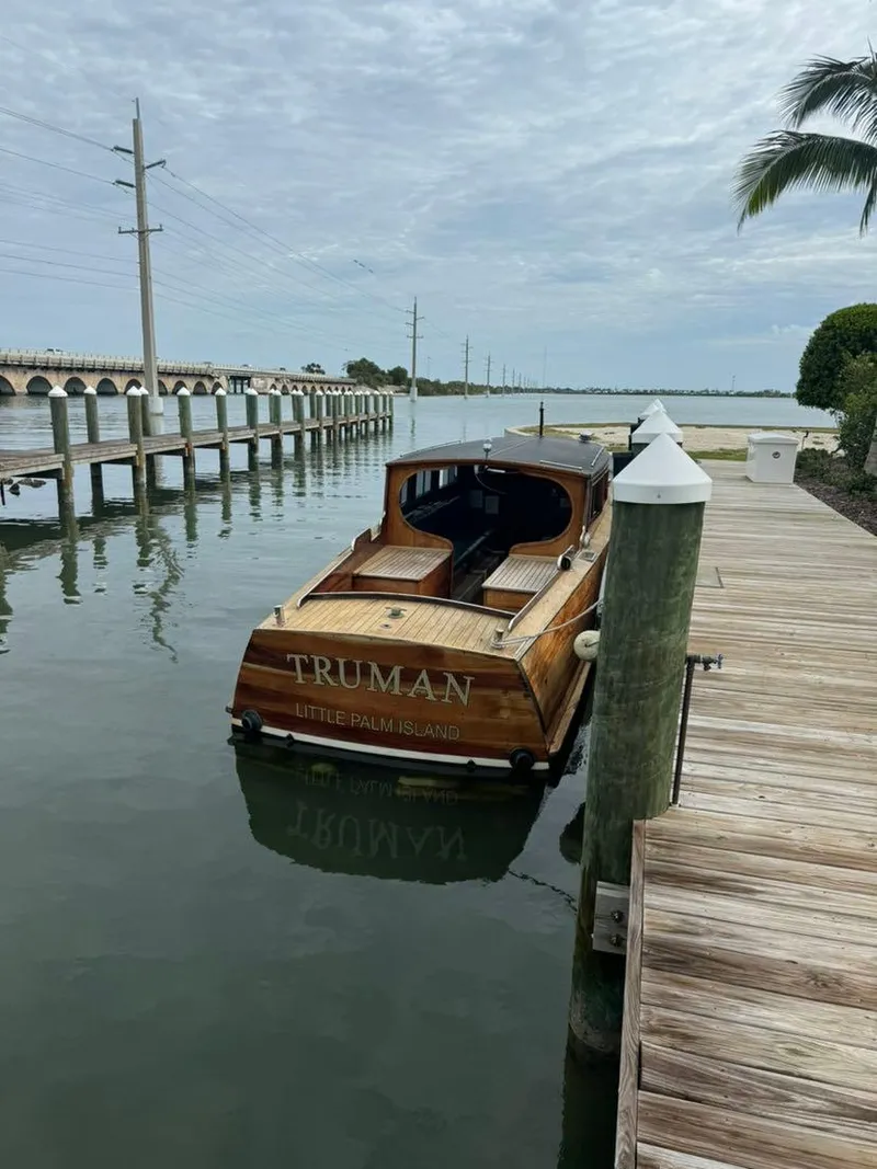 Slide: The Image of 1994 Grand Craft 37 boat docked by a wooden pier, under a cloudy sky. - 3