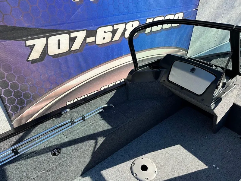 Slide: The Image of 2024 Lund 1650 Angler Sport boat interior with windshield and fishing rod holders. - 13