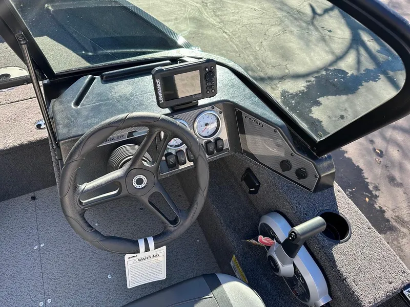 Slide: The Image of 2024 Lund 1650 Angler Sport boat dashboard with steering wheel and controls. - 15