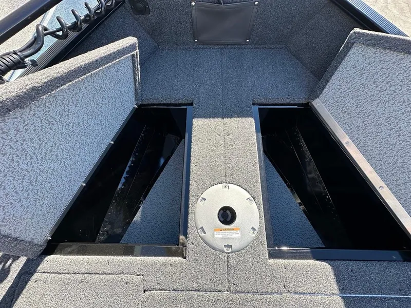 Slide: The Image of 2024 Lund 1650 Angler Sport boat storage compartments open, showcasing interior space. - 26
