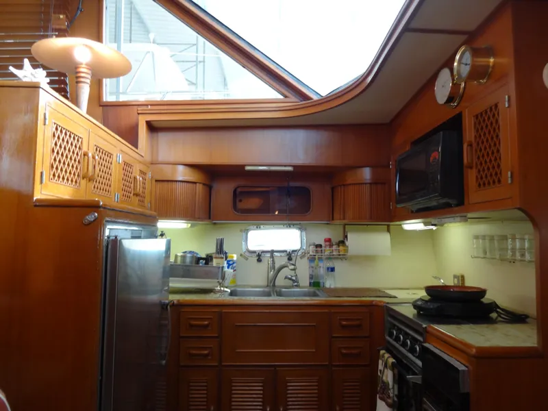 Slide: The Image of 1989 Hi-Star AFT CABIN SUNDECK MOTOR YACHT kitchen with wood cabinetry and modern appliances. - 24