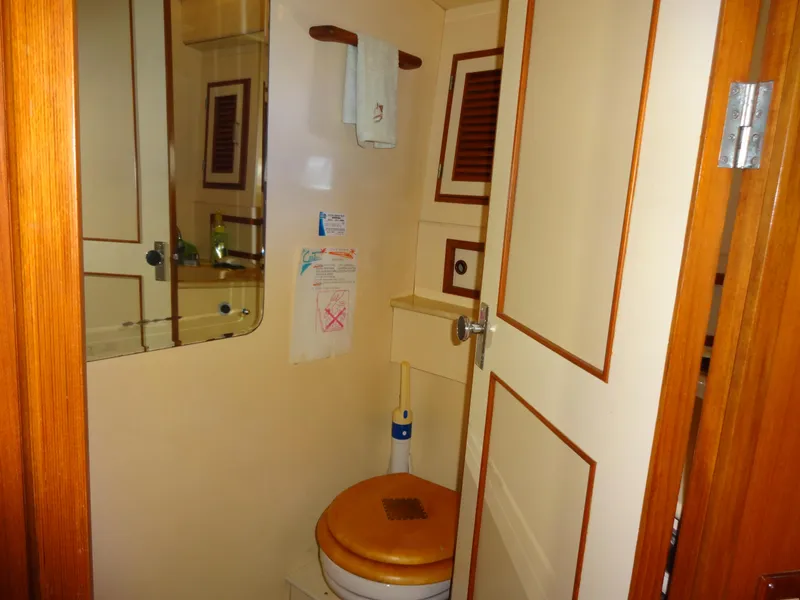 Slide: The Image of 1989 Hi-Star motor yacht bathroom with wooden accents and mirror. - 33