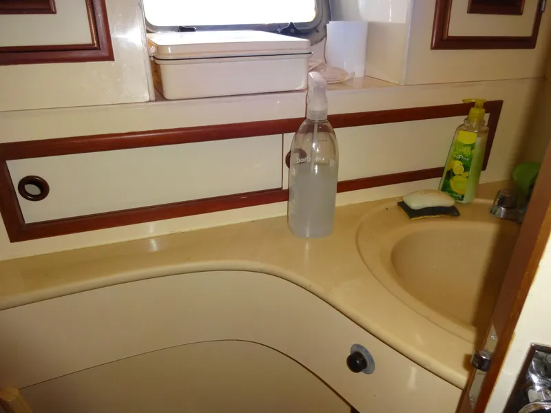 Slide: The Image of 1989 Hi-Star yacht bathroom with sink, cleaning supplies, and window. - 34