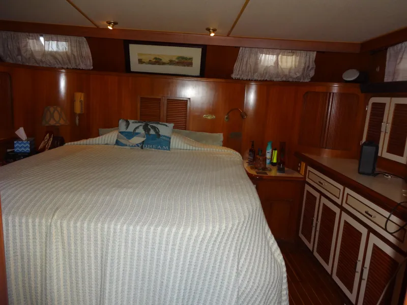 Slide: The Image of 1989 Hi-Star AFT Cabin Sundeck Motor Yacht bedroom with wood paneling and cozy bedding. - 39
