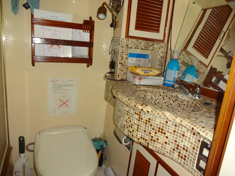 Slide: The Image of 1989 Hi-Star yacht bathroom with mosaic sink, toilet, and storage cabinets. - 43