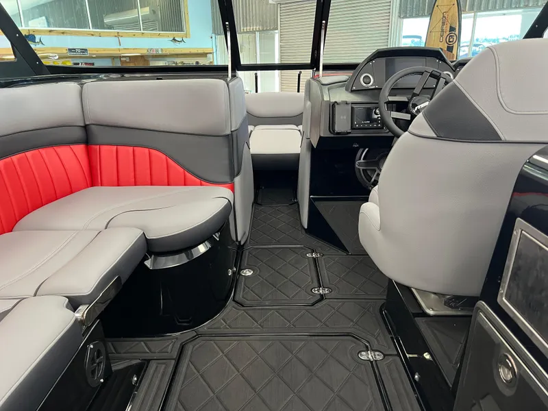 Slide: The Image of 2024 MB B52 boat interior with gray and red seating, modern dashboard, and quilted flooring. - 6