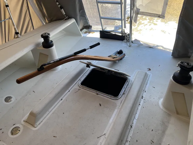 Slide: The Image of Interior of a 2007 Custom Hallett 33 boat with open hatch and wooden tiller. - 18