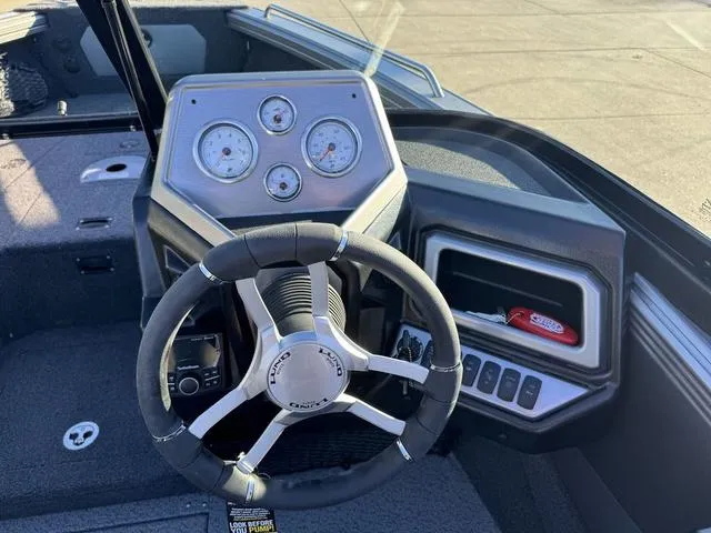 Slide: The Image of 2024 Lund 1975 Tyee Sport boat dashboard with steering wheel and gauges. - 11