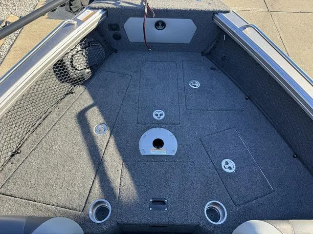 Slide: The Image of 2024 Lund 1975 Tyee Sport boat interior with carpeted deck and storage compartments. - 14