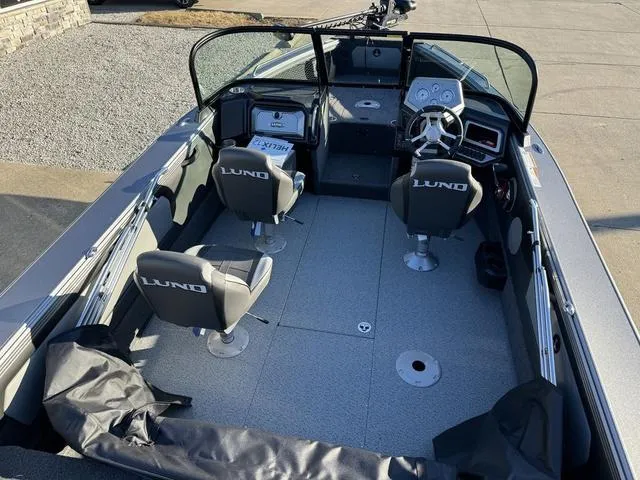 Slide: The Image of 2024 Lund 1975 Tyee Sport boat interior with seating and steering console. - 9