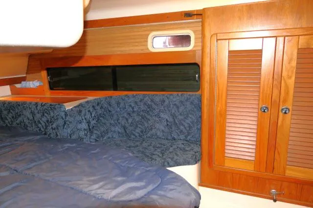 Slide: The Image of Interior cabin of 1997 Catalina 380 sailboat with wood paneling and blue upholstery. - 15
