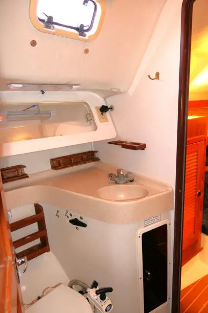 Slide: The Image of 1997 Catalina 380 yacht bathroom with sink, mirror, and storage shelves. - 17