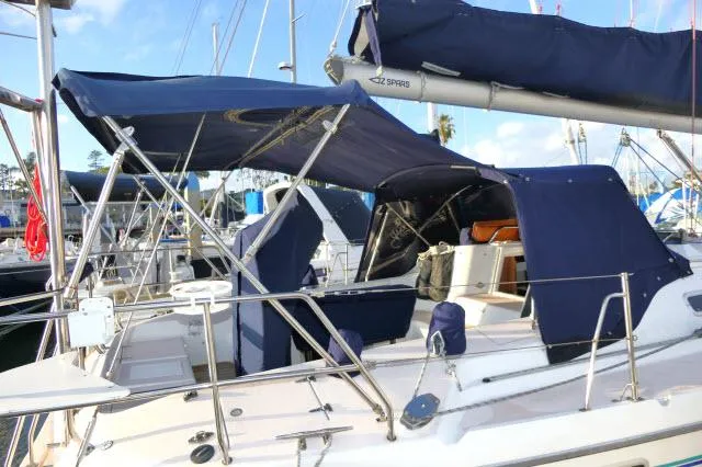 Slide: The Image of 1997 Catalina 380 sailboat with blue canvas covers in a marina. - 28