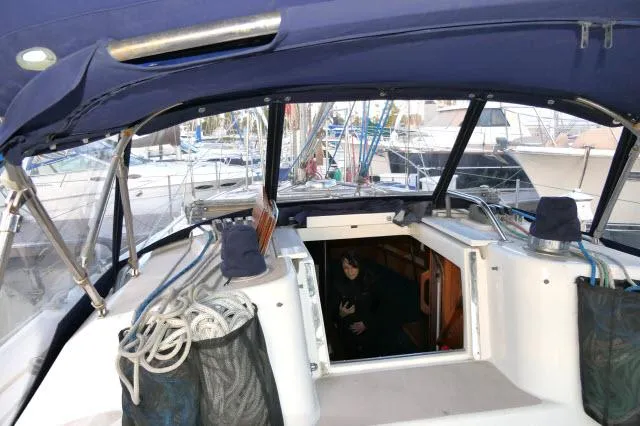 Slide: The Image of 1997 Catalina 380 yacht cockpit with blue canopy and visible marina background. - 29