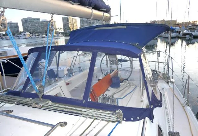 Slide: The Image of 1997 Catalina 380 sailboat with blue canopy docked in marina. - 30