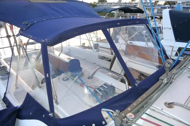 Slide: The Image of 1997 Catalina 380 sailboat with blue canvas cover and clear panels in marina. - 31