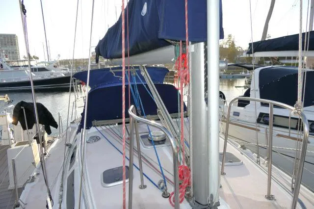 Slide: The Image of 1997 Catalina 380 sailboat docked, featuring blue sail covers and rigging. - 37