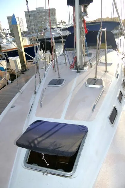 Slide: The Image of 1997 Catalina 380 sailboat deck with open hatch, docked in marina. - 38