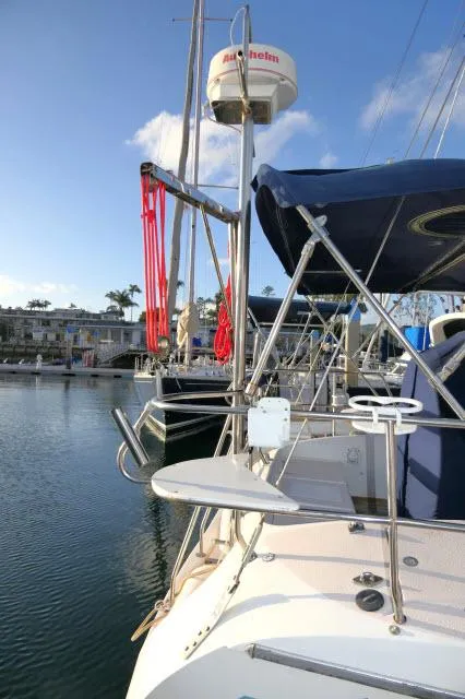 Slide: The Image of 1997 Catalina 380 sailboat docked in marina, featuring radar and blue canopy. - 42
