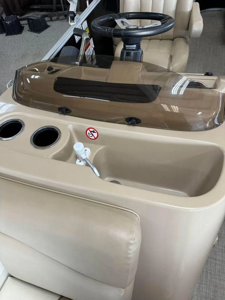 Slide: The Image of 2016 Bennington 24 SLX boat console with steering wheel and beige seating. - 9