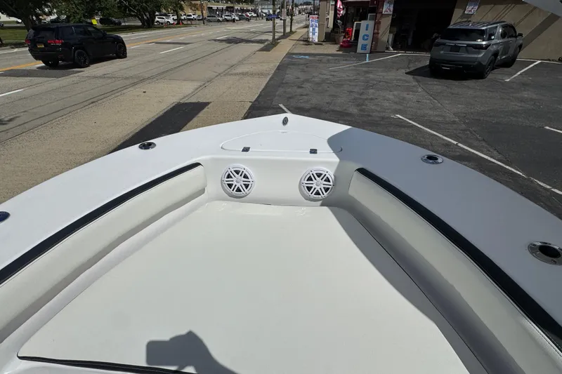 Slide: The Image of 2024 Tidewater 180 CC boat bow with seating and speakers, parked near a street. - 15