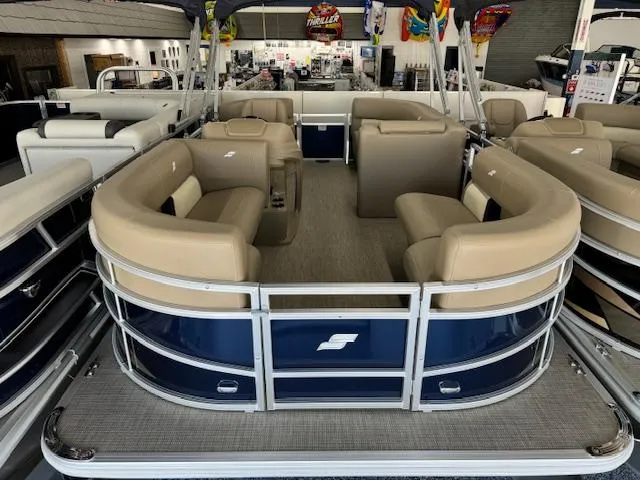 Slide: The Image of 2024 Starcraft LX 18 R pontoon boat with beige seating and blue exterior. - 2