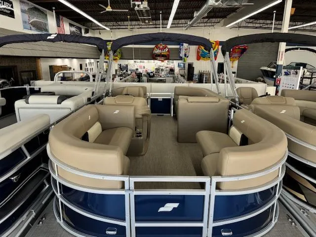 Slide: The Image of 2024 Starcraft LX 18 R pontoon boat with beige seating in showroom. - 3