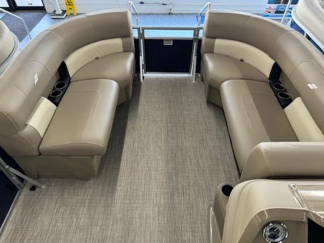 Slide: The Image of 2024 Starcraft LX 18 R pontoon boat interior with beige seating and cup holders. - 4
