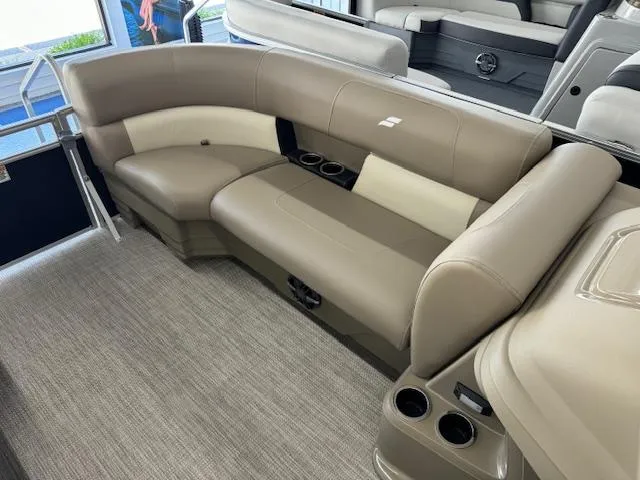 Slide: The Image of 2024 Starcraft LX 18 R pontoon boat interior with beige seating and cup holders. - 7