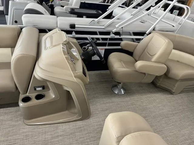 Slide: The Image of 2024 Starcraft LX 18 R pontoon boat interior with beige seating and helm. - 9