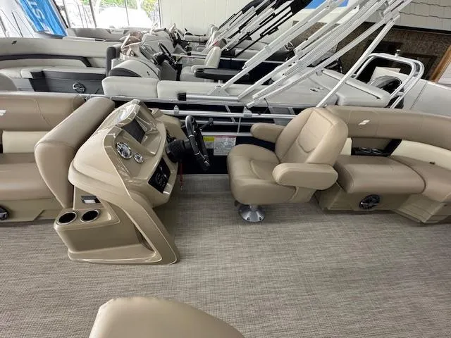 Slide: The Image of 2024 Starcraft LX 20 R pontoon boat interior with beige seating and modern dashboard. - 10
