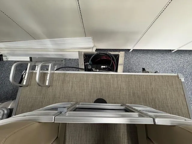 Slide: The Image of 2024 Starcraft LX 20 R pontoon boat interior with ladder and storage compartment. - 15