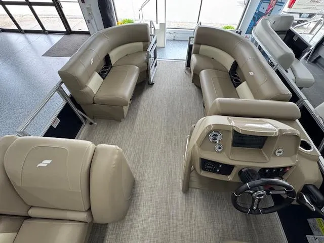Slide: The Image of 2024 Starcraft LX 20 R pontoon boat interior with beige seating and modern dashboard. - 5