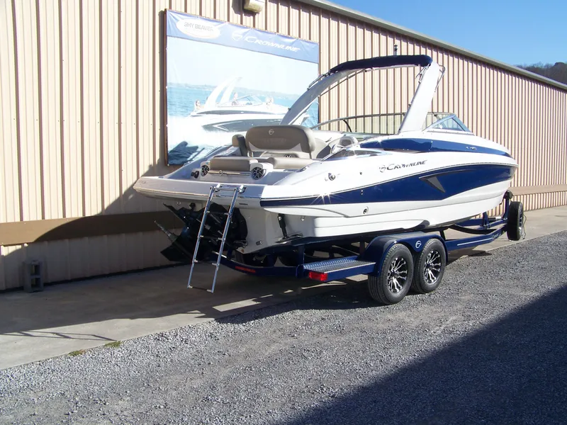 Slide: The Image of 2024 Crownline 280 boat on trailer, parked outside a building. - 3