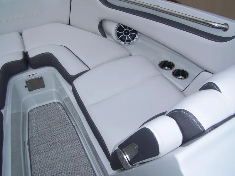Slide: The Image of 2024 Crownline 260 boat interior with white and gray seating, cup holders, and speaker. - 5