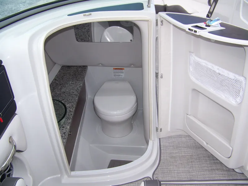 Slide: The Image of 2024 Crownline 260 boat interior bathroom with toilet and storage. - 9