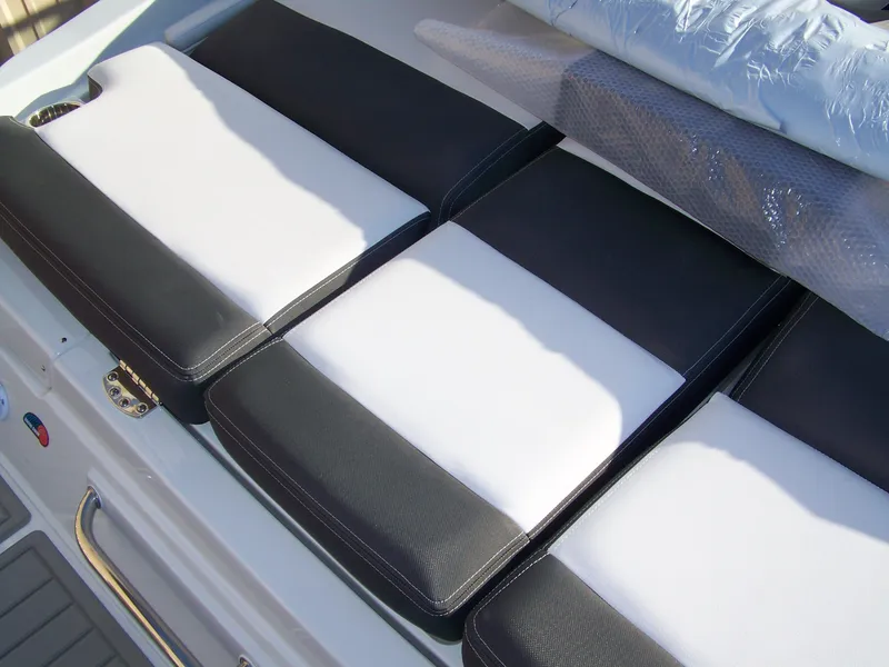 Slide: The Image of 2024 Crownline 240 boat with black and white cushioned seating. - 6