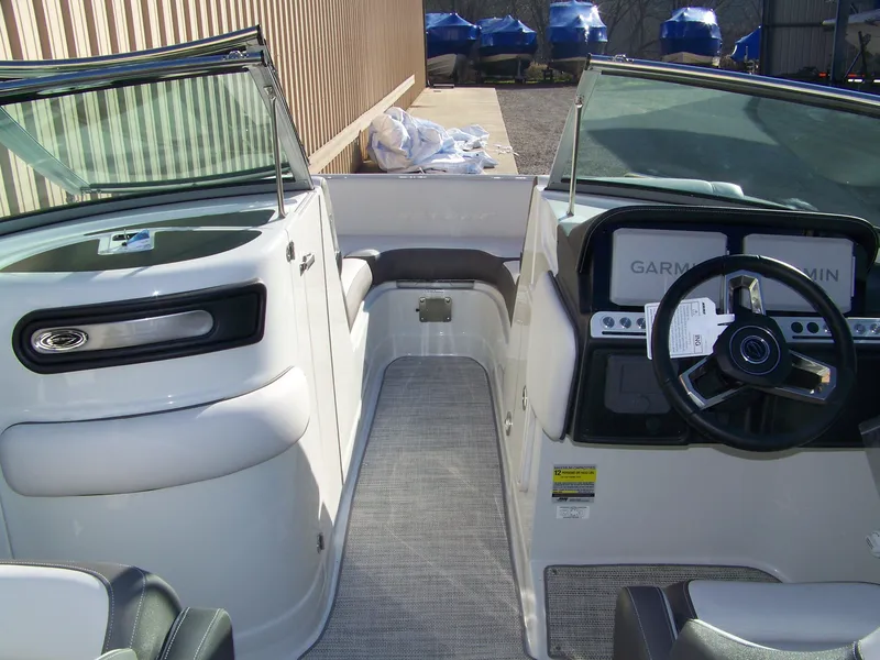 Slide: The Image of 2024 Crownline E235 boat interior with steering wheel and seating area. - 5
