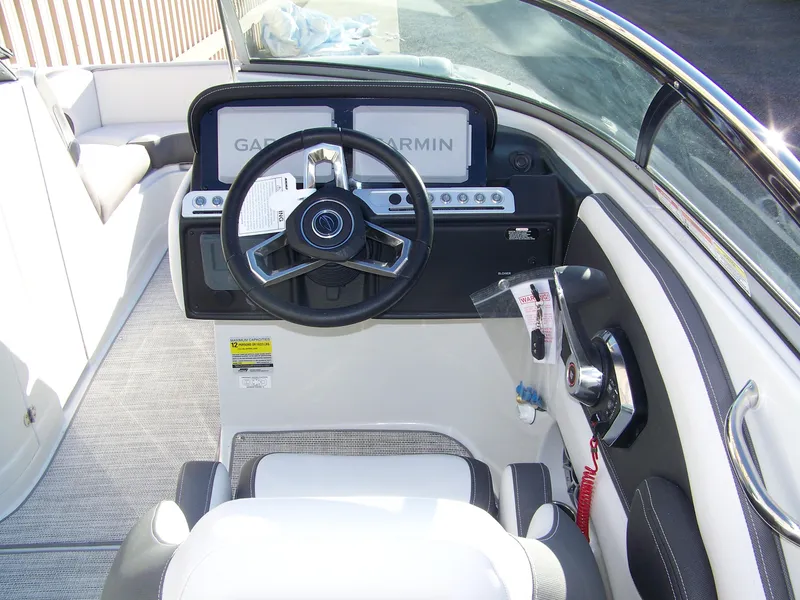 Slide: The Image of 2024 Crownline E235 boat cockpit with steering wheel and Garmin navigation system. - 8