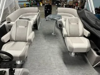 Slide: The Image of 2023 Sweetwater 2286SBX pontoon boat interior with plush seating and table. - 11