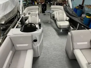 Slide: The Image of 2023 Sweetwater 2286SBX pontoon boat interior with plush seating and helm station. - 12