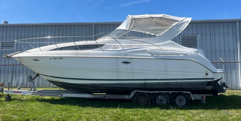 Slide: The Image of 1999 Bayliner 3055 Ciera boat on trailer, parked outdoors near a metal building. - 0