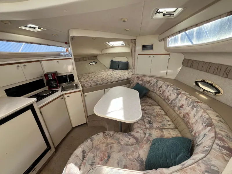 Slide: The Image of 1999 Bayliner 3055 Ciera cabin interior with kitchenette, seating area, and bed. - 1