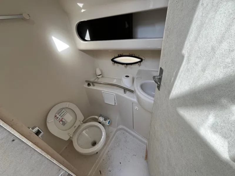 Slide: The Image of 1999 Bayliner 3055 Ciera boat bathroom with toilet, sink, and window. - 4