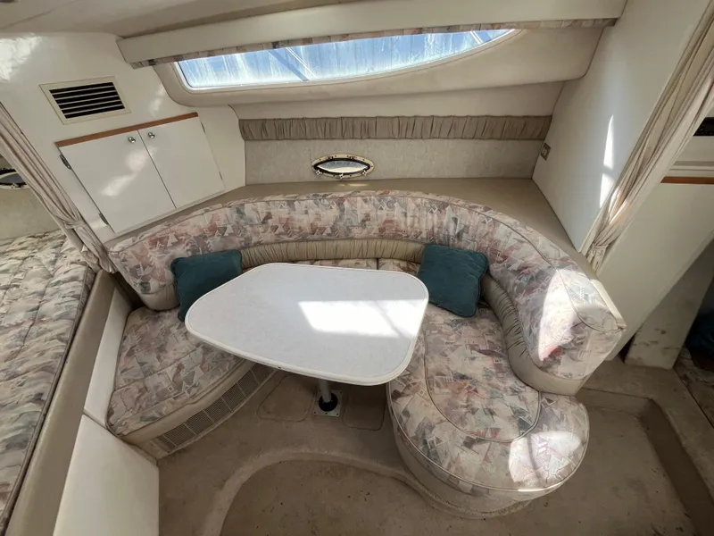 Slide: The Image of 1999 Bayliner 3055 Ciera interior with curved seating and table, featuring patterned upholstery. - 5