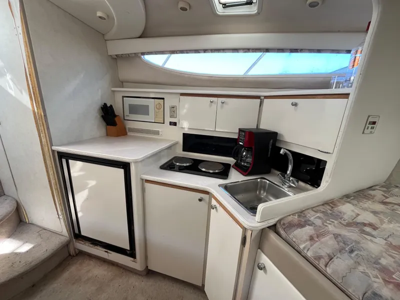 Slide: The Image of 1999 Bayliner 3055 Ciera boat kitchen with microwave, sink, and stove. - 6